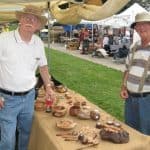 2 men posing for photo at his selling booth